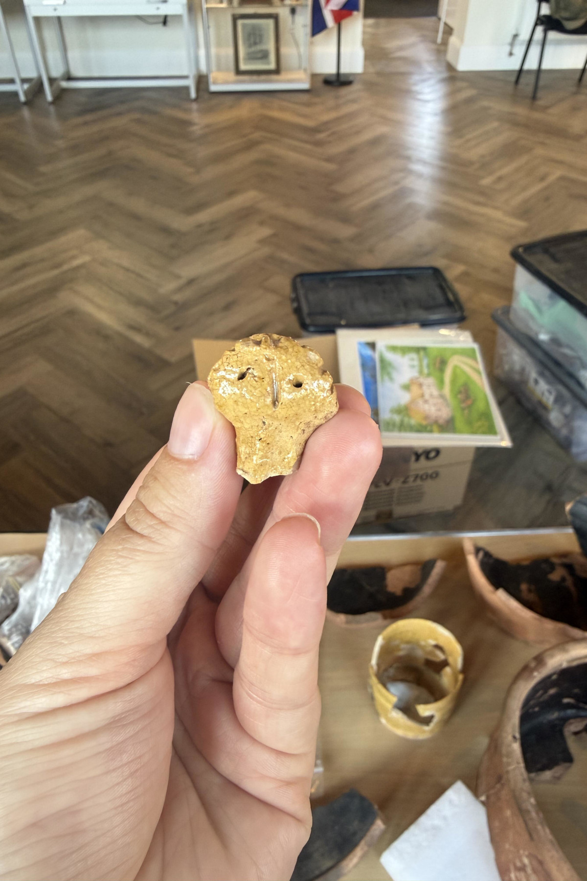 This fragment of a Midland Yellow head is a second moulded lady figure recovered from the site. The figure would adorn the top of the handle of a Midland Yellow mug. It may actually be from the yellow ware mug visible in the picture to the right of the hald holding the head. The first example can be seen in the 2025 finds for September