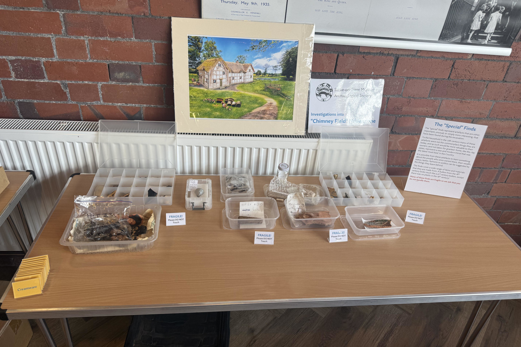 Some of the 'special' finds being set out. These are generally displayed in their packaging as many are fragile. The image on the wall is a high resolution scan of the reconstruction painting of the building in Chimney Field by Jane Fern-Whitington